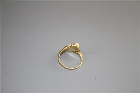 A 20th century 18ct and two stone cultured pearl set crossover ring, size O, gross weight 3.3 grams.